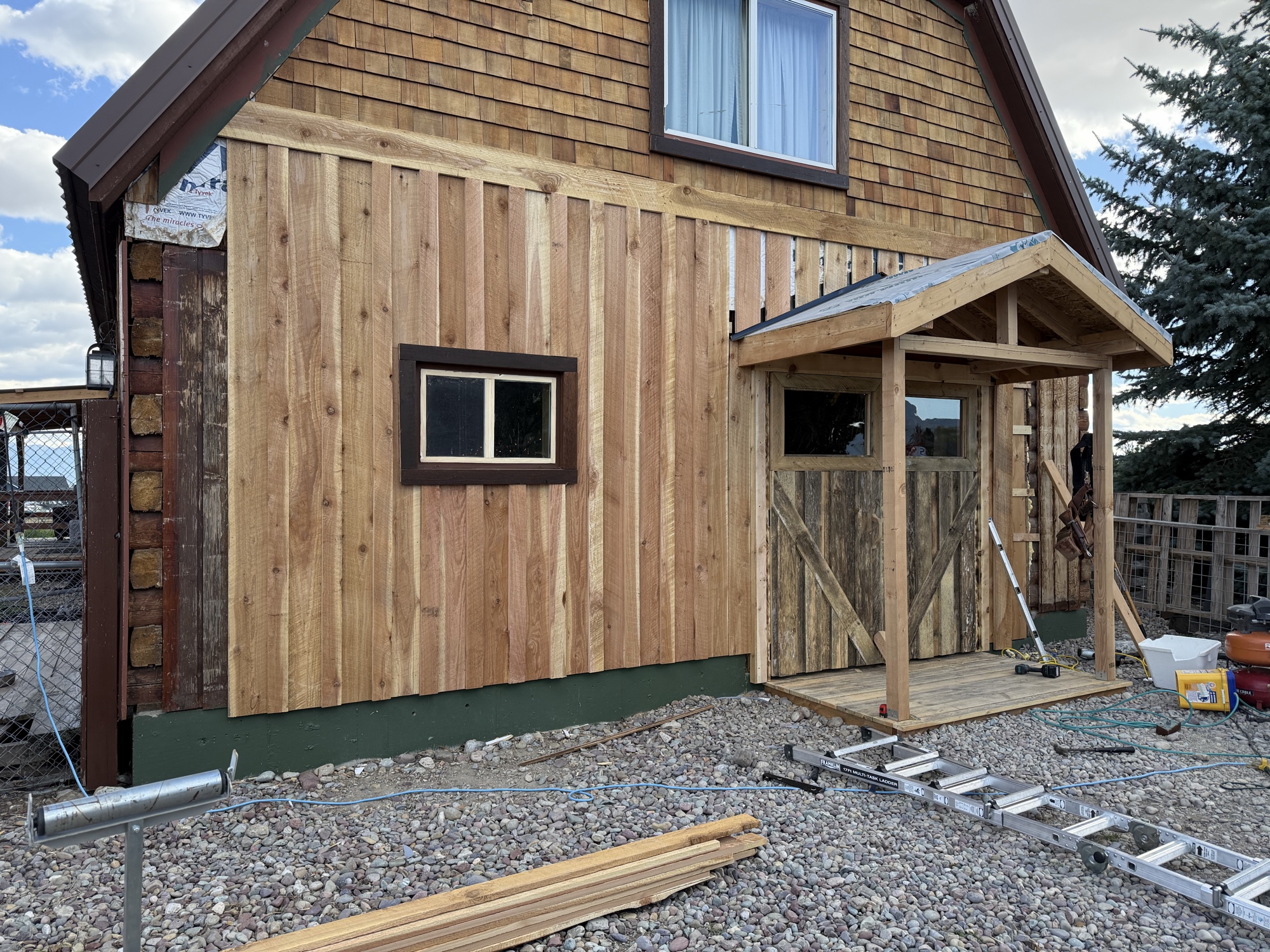 New cedar barn exterior construction with covered entry