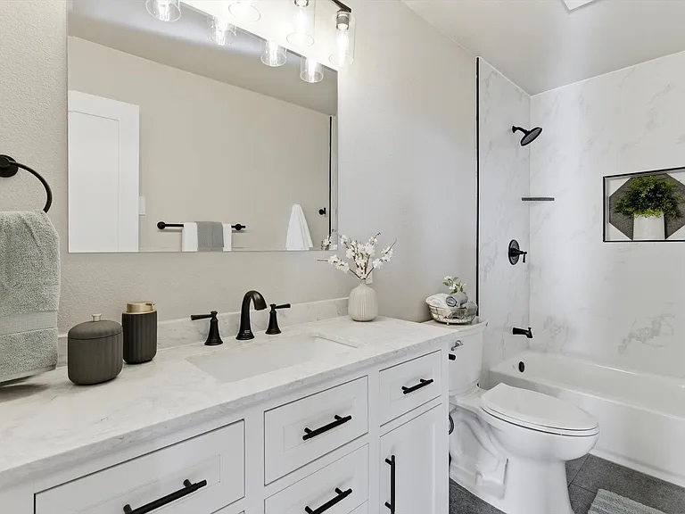Bright modern bathroom remodel with marble tile and black fixtures