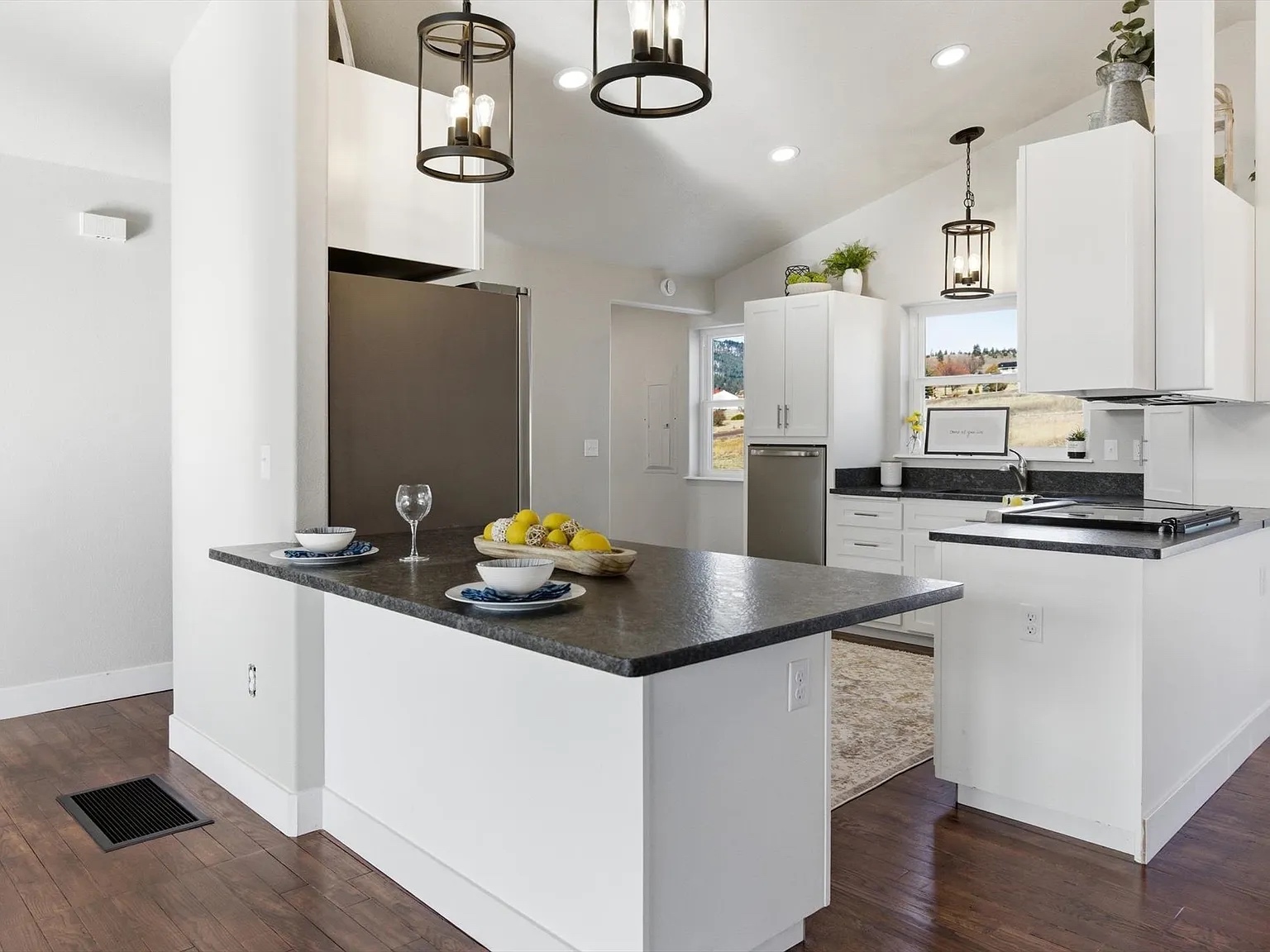 New construction kitchen with dark island countertop and white cabinetry