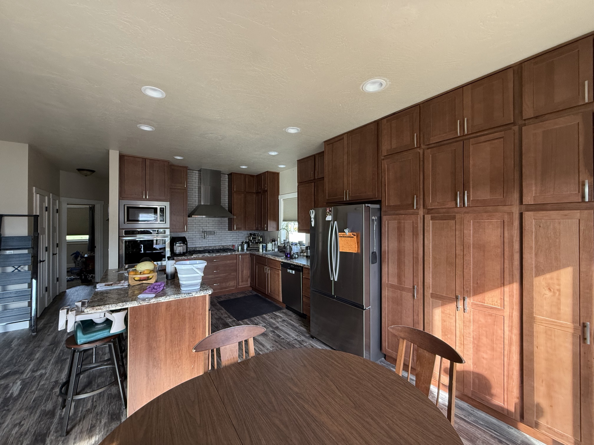 Kitchen renovation with rich walnut cabinetry, granite island, and stainless appliances
