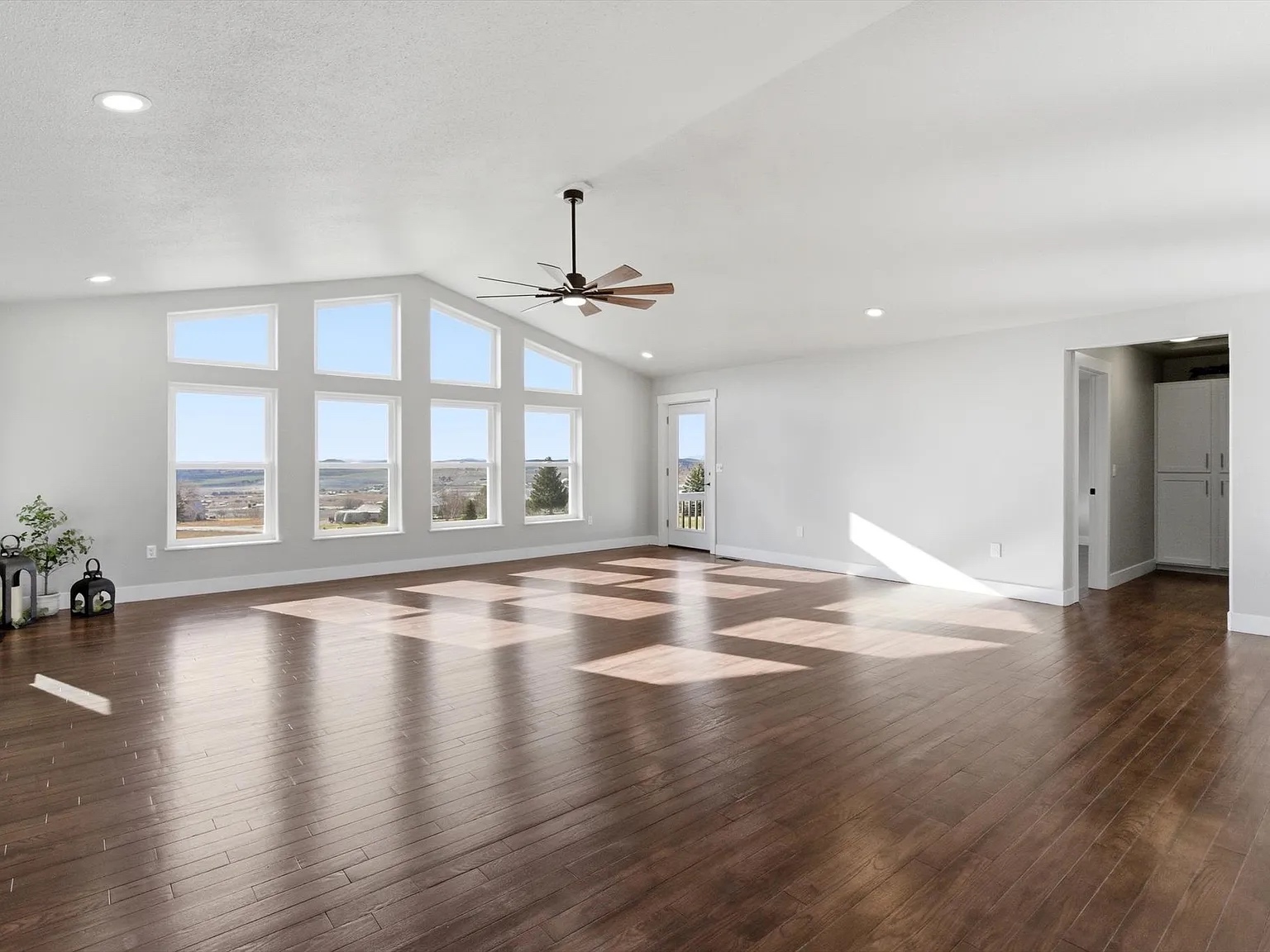 Spacious new construction living room with large windows and hardwood floors